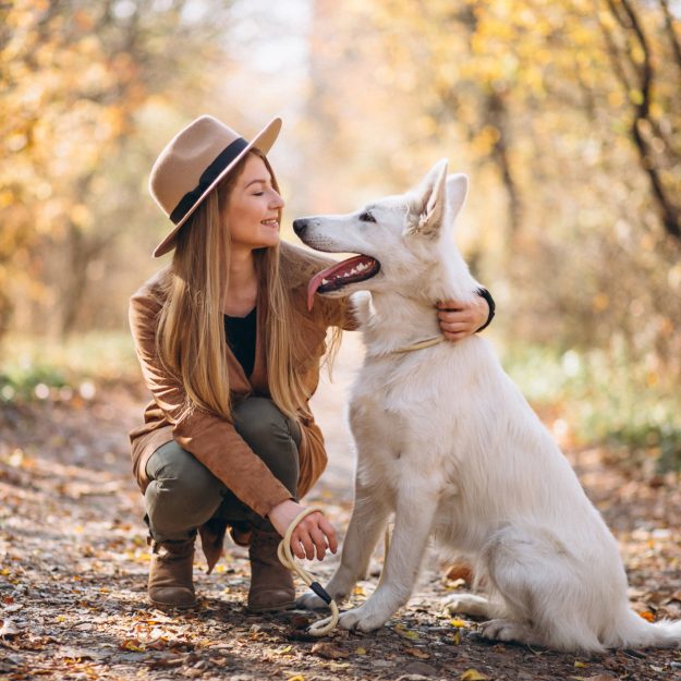 Young woman in park with her white dog
